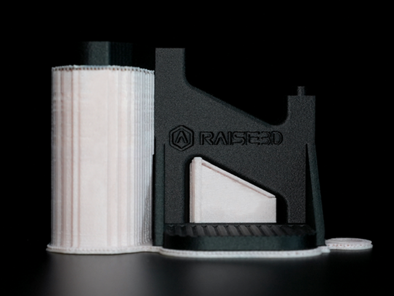 Una pieza impresa en 3D con el filamento Raise3D PA12 CF+ Industrial y un filamento de soporte